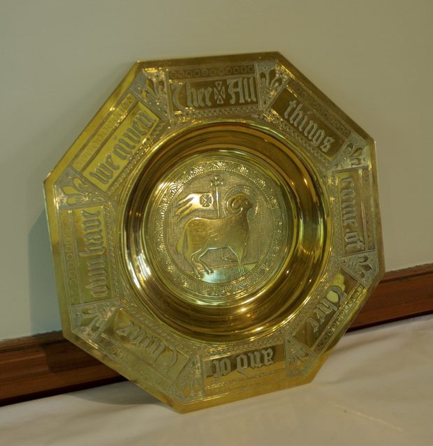 A brass bowl with a sheep at the center. The bowl reads: All things come of thee o lord and of thine own.