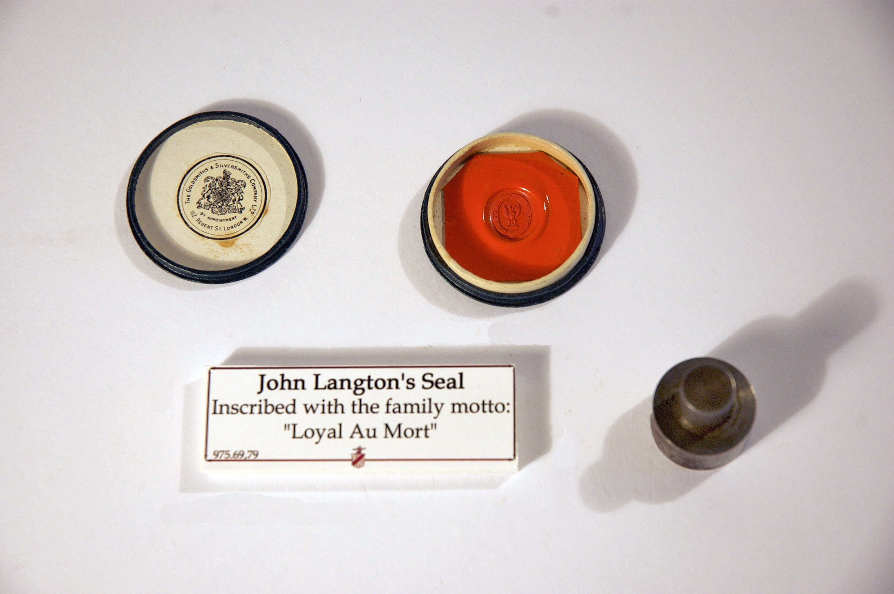 Measuring just under 2 inches in diameter, picture shows the red seal of John Langton, inscribed with family motto "Loyal Au Mort" The lid to the seal box is to the left of the seal. To the right of the seal, is ink which would of been applied.
