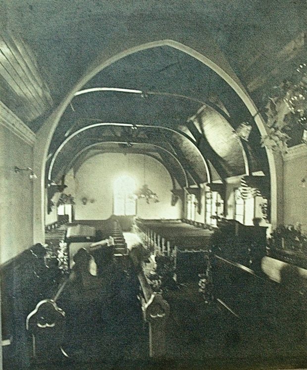 Black and white photograph taken circa 1908 of current St. James looking from back of altar to the back of the church.