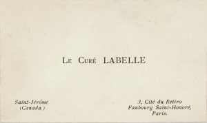 Image of a small rectangular white card: printed in the centre, in black ink, are the words “Le Curé Labelle.” At bottom left and right are the curé’s addresses in Canada and France.