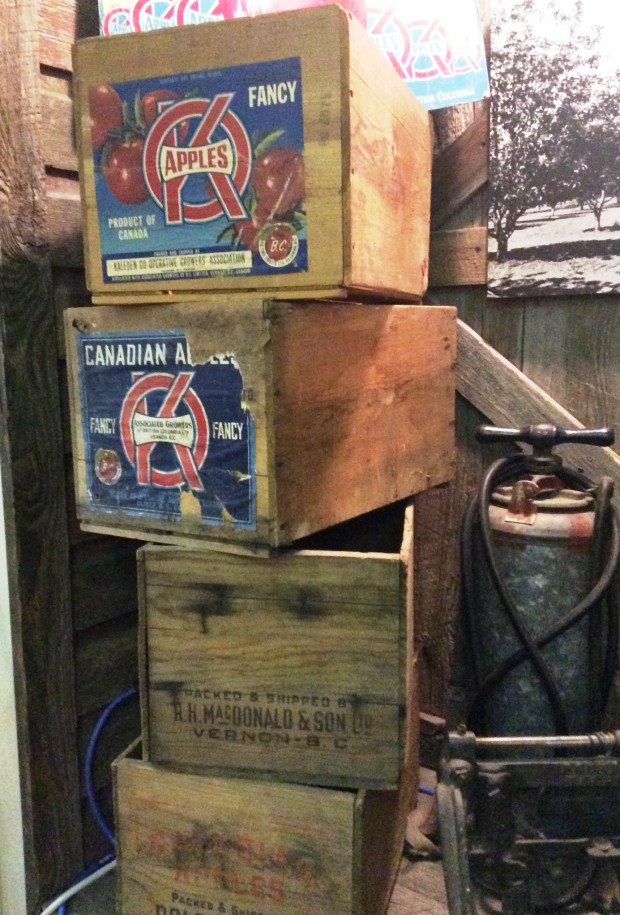 Colour photo of a stack of four wooden apple boxes. The top two have OK Brand labels.