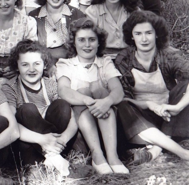 Section of a black and white photo of three young women sitting on the grass.