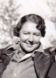 Black and white photo of a woman in her early thirties smiling at the camera.