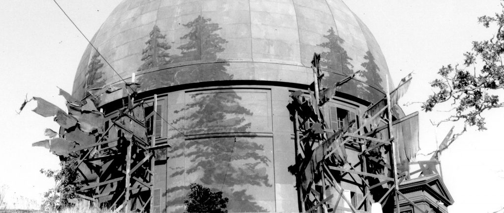 Black and white photograph of telescope dome painted to look like forest.