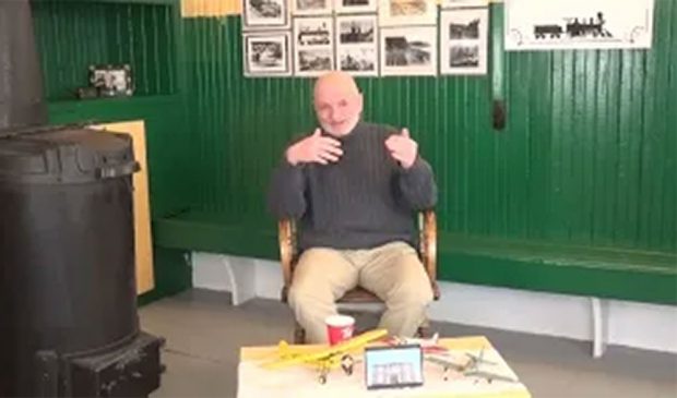 A coloured photograph of Patrick J. Collins sat in a chair during an interview.