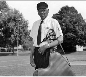 Senior man in umpires uniform, baseball field in the background