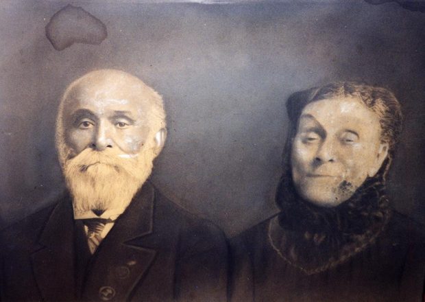 Sepia colored portrait of senior couple, formal dress,seated, male; left full white beard, female right hair pulled back, dress with high trimmed collar.