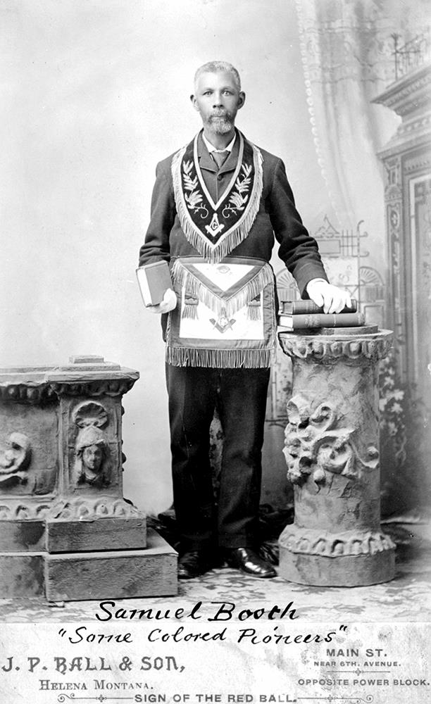 man with gray beard standing, dressed in masonic regalia.