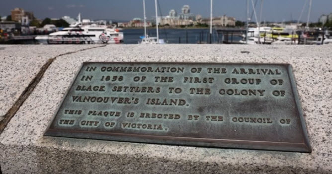 bronze plaque inlaid on top of a concrete causeway wall.