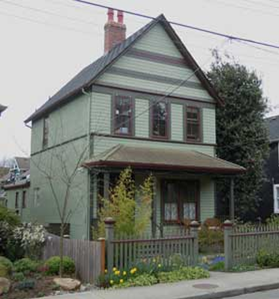 2 story front-gabled house, verandah, gray with burgundy trim
