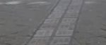public square showing pavement with double row of gray bricks with etched names