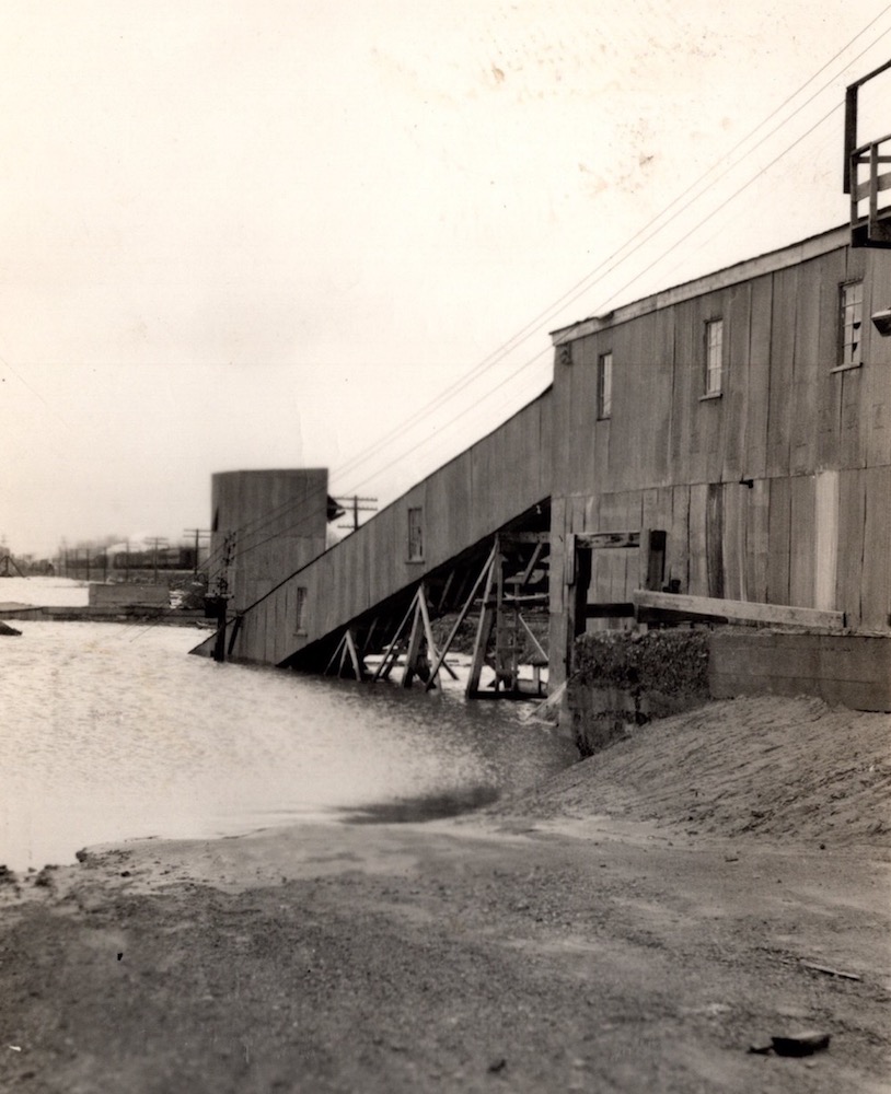 Black and white photograph of a quarry building partially submerged in water
