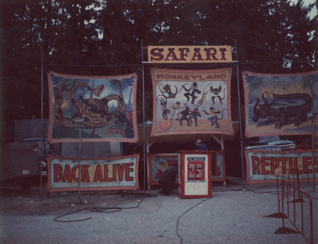 A carnival sideshow entrance for an exotic animal show, title reads Safari, there are painted banners depicting several kinds of exotic animals, and admission is advertised as 25 cents