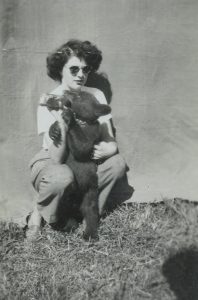 Une photo en noir et blanc de la jeune Jackie Hauser en train de nourrir un ourson noir au biberon