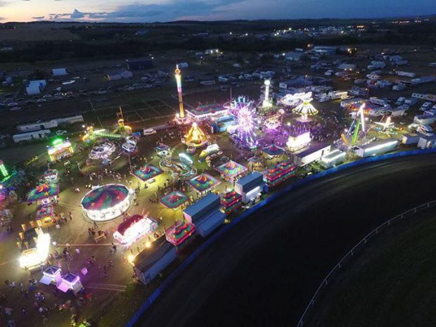 Bird's eye view of carnival midway at dusk, the lights shine bright from a distance