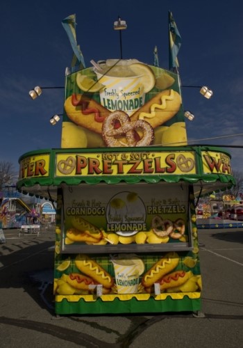 A hot and soft large pretzel concession stand, also advertising corn dogs and lemonade with colourful graphics