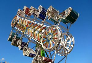 Les gondoles du manège Zipper présentent des couleurs différentes sur les côtés verticaux, les gondoles tournent sur elles-mêmes tout en faisant un tour un peu comme une grande roue