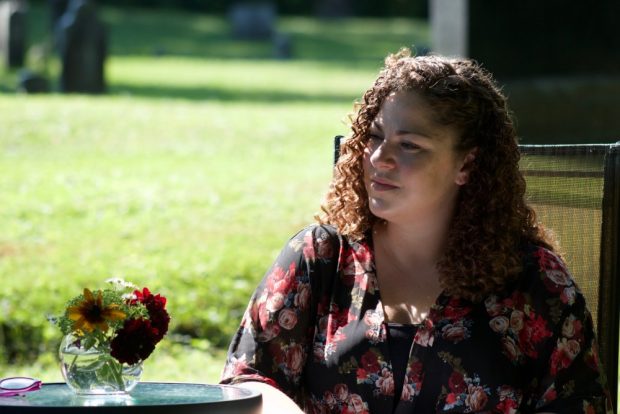 Coloured photograph of Jennifer Dow is seated with a green lawn behind her.