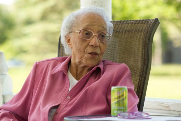 Coloured photograph of June Carty seated outside during her interview.