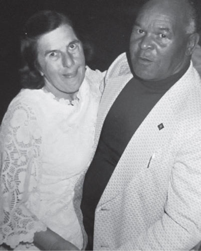 Black and white archival photo of a white woman and Black man standing in a dance pose.