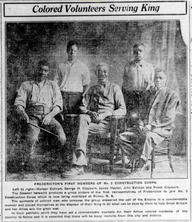 Newspaper clipping with image of 5 Black men, three seated in wooden chairs and two standing.