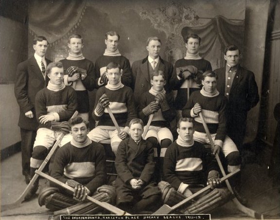 A group of men seated and standing in three rows, posing for a team photo.