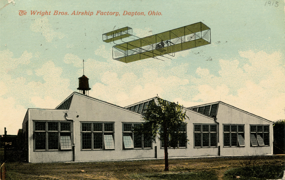 Bi-plane flying above buildings.