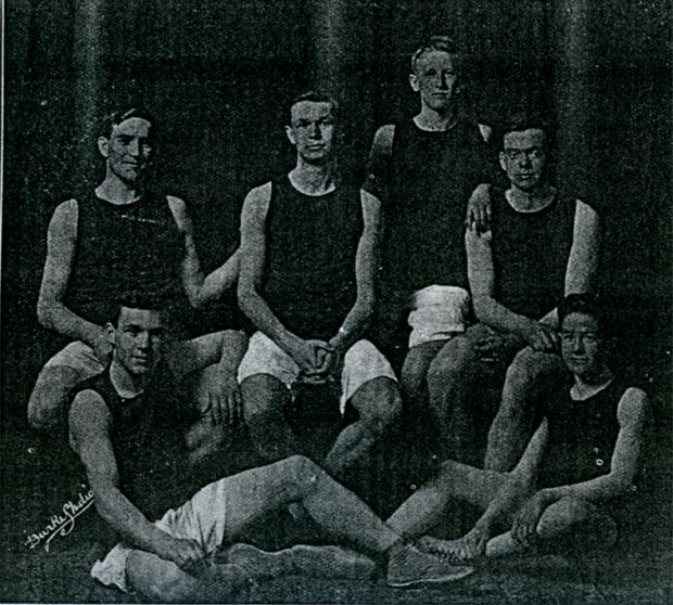Six men grouped together wearing basketball uniforms.