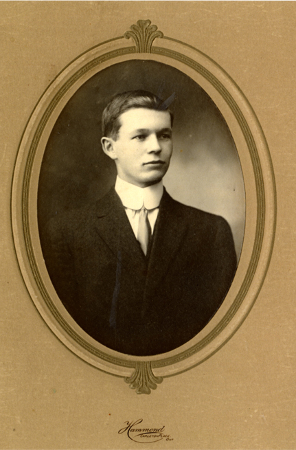 A man in a dark suit and a high collared shirt.