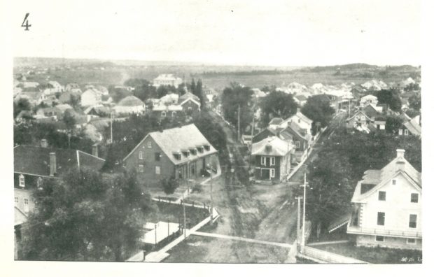 Black and white photograph of Montmagny. Wooden houses with steep pitched roofs line the streets of the village.