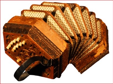 Colour photograph of a hexagonal-shaped concertina accordion with the bellows extended.