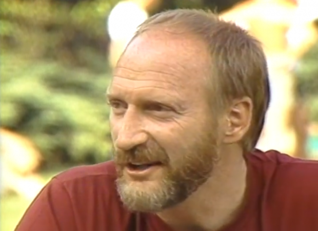 Tom Waddell is interviewed by Mary Anne McEwen about the origin of the Gay Games. They are sitting on a park picnic table at a venue of the 1983 Vancouver Gay Summer Games.