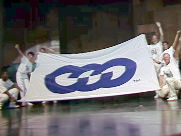The Gay Games flag for Gay Games IV is held up by the winning bid team.