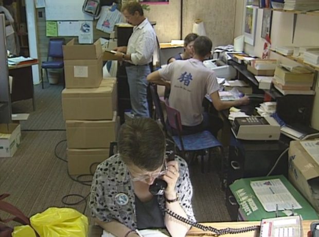Four volunteers and staff busy working in a crowded Celebration '90 Office at Enterprise Hall the day before registration opens.