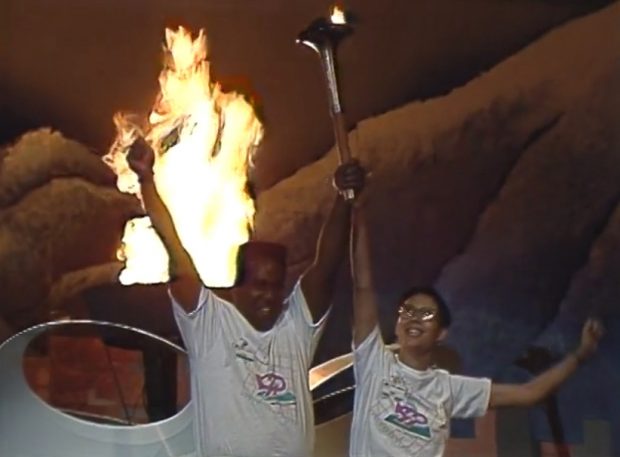 Torch bearers Woolly Taylor and Marlene Wong raise their arms in triumph after igniting the Celebration ’90 Flame at B.C. Place Stadium.