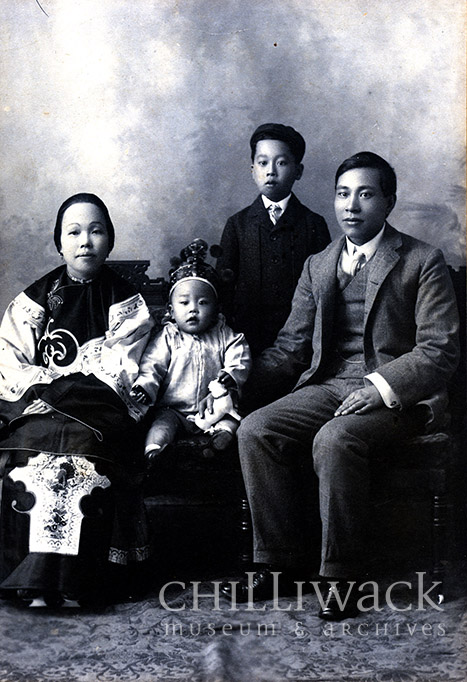 Formal black and white portrait of who is assumed to be the Yip On family. The youngest is in the centre wearing a crown with the mother on left and father on right. Their young boy is standing off centre behind the seated family.