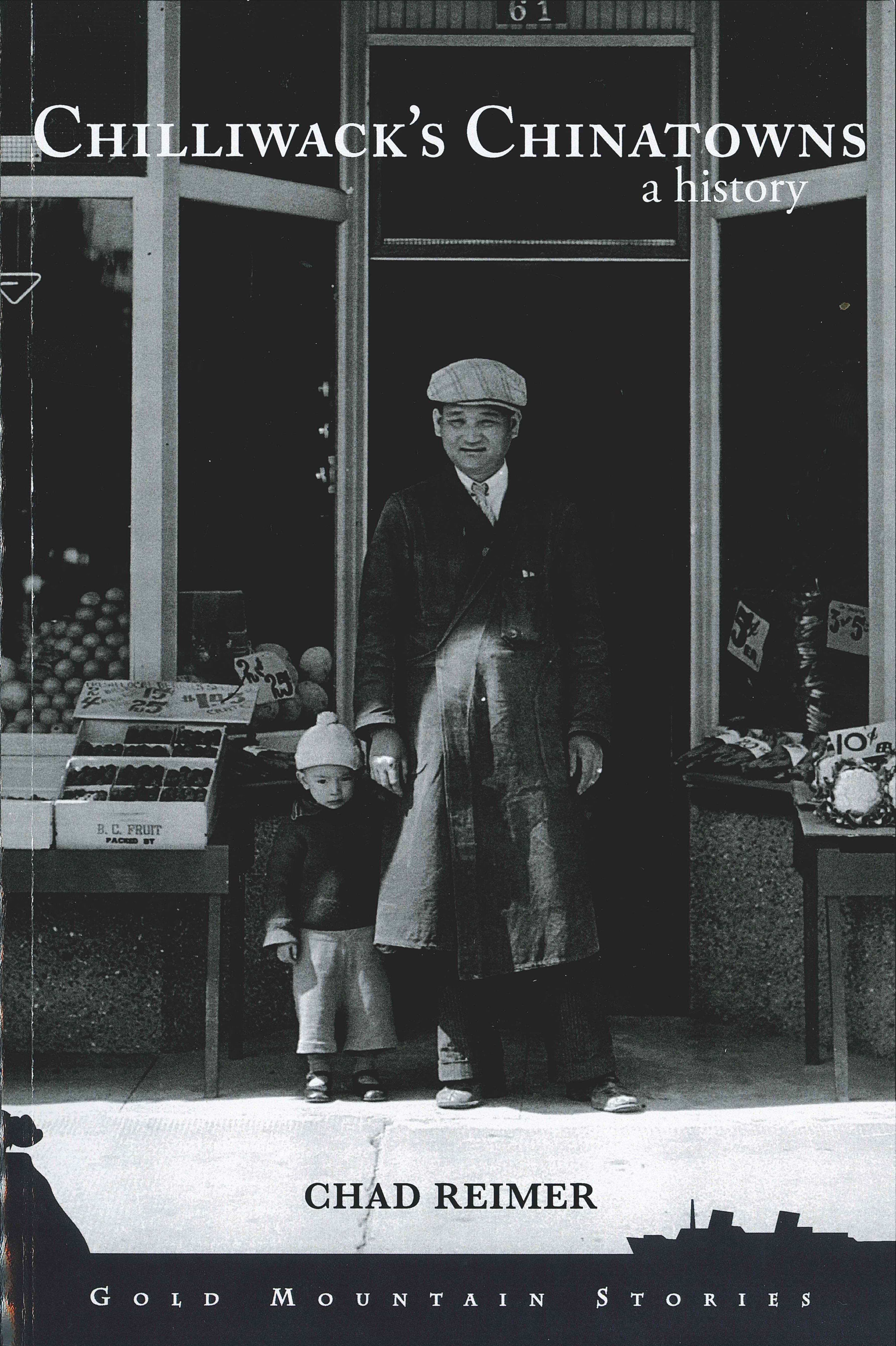 Front cover of the book, “Chilliwack’s Chinatowns: A History,” by Dr. Chad Reimer. The cover has a black and white photo of a young boy and a man standing hand in hand in front of a merchant’s store. Fruit stalls are to the left and vegetable stalls are to the right.