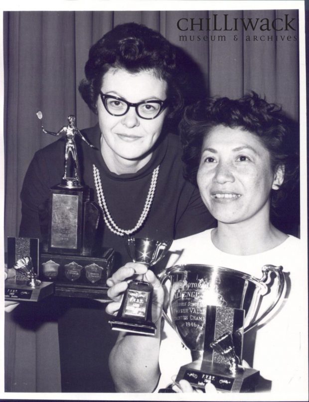 Two women (Dorothy Kostrzewa on the right) hold badminton trophies
