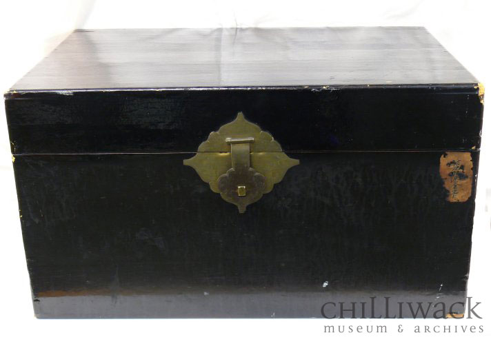 Black painted wooden trunk with four rectangular metal hinges and front clasp