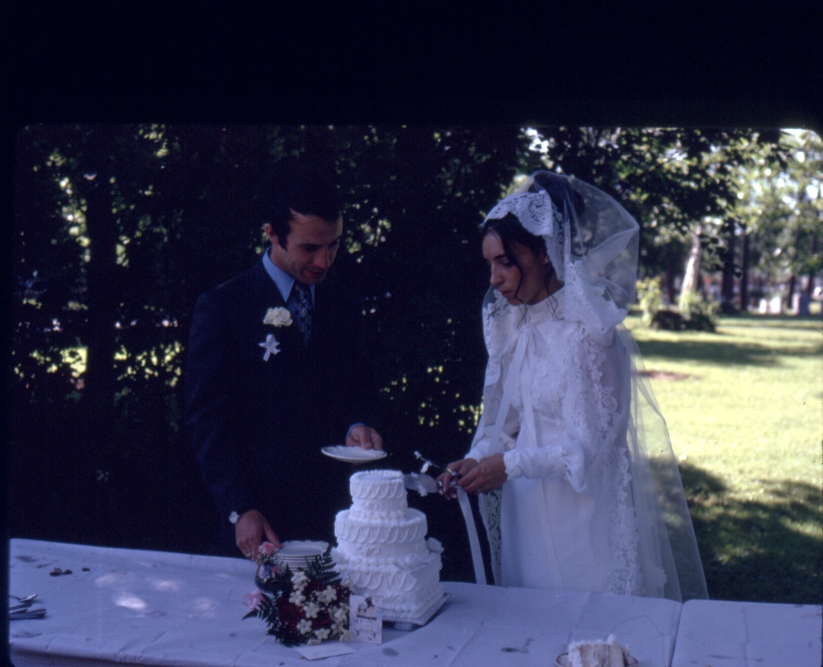 Coloured picture of a man and a woman cutting a wedding cake at their wedding