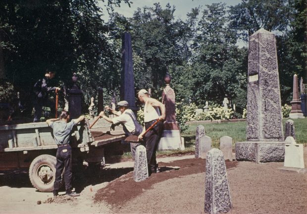 Coloured picture of men working on a cemetery plot with a tractor