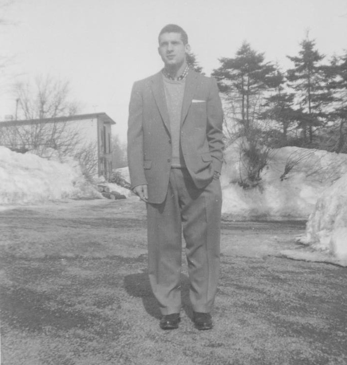 Gray photo of a man standing in front of building