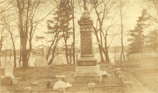 Sepia picture of a monument surrounded by trees and has a view of the river behind the monument.