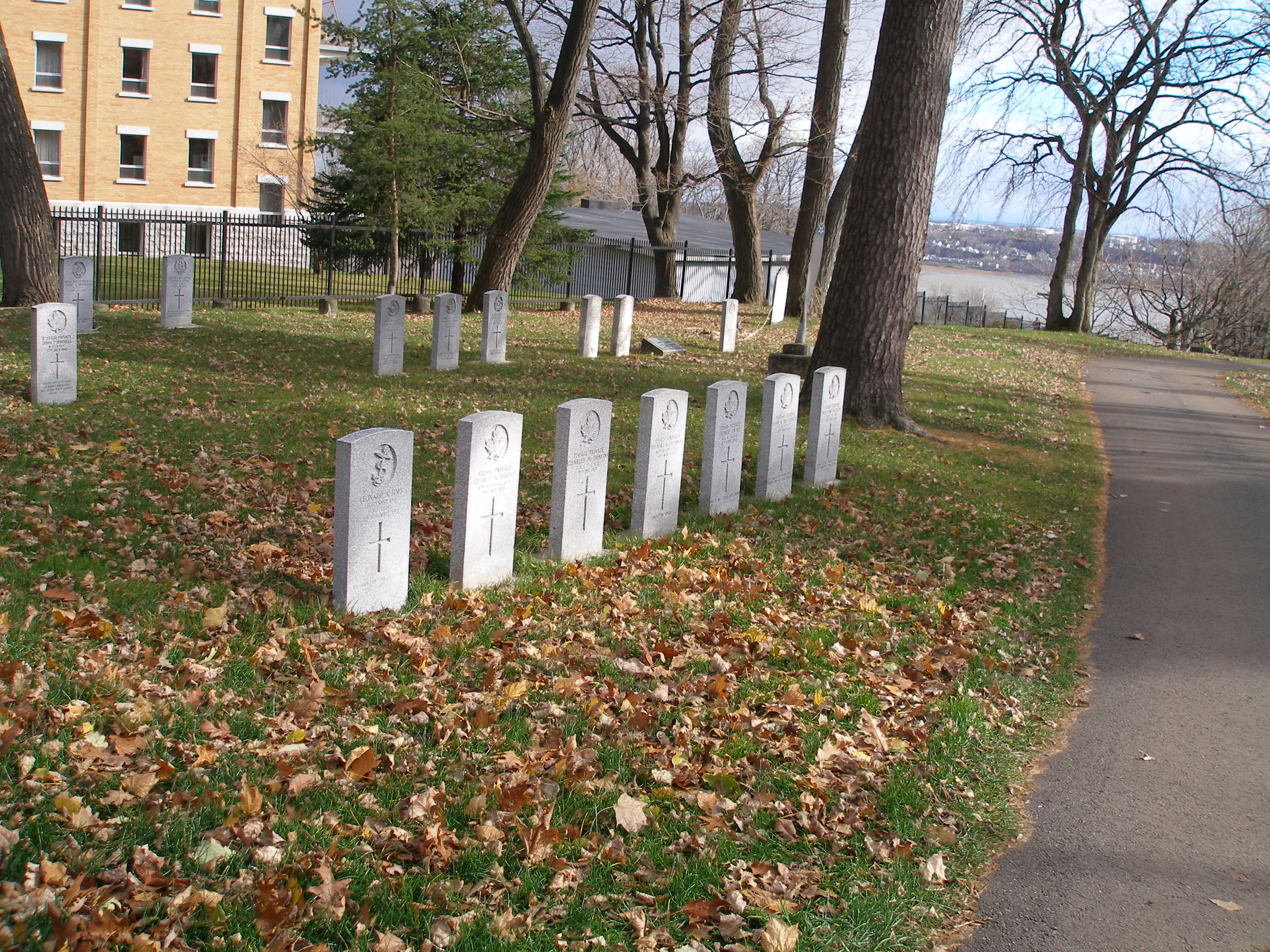 headstone in line with fall leaves all around them