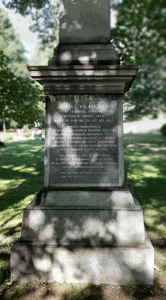 Coloured picture of a marble tombstone in the grass and surrounded by trees