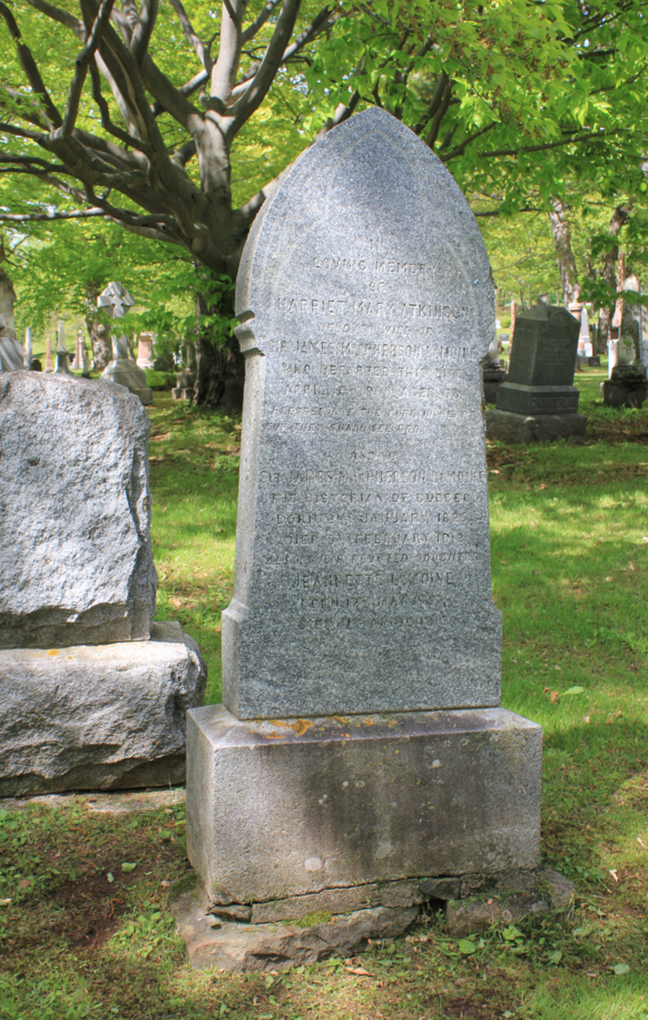 Grey headstone in the front in the grass