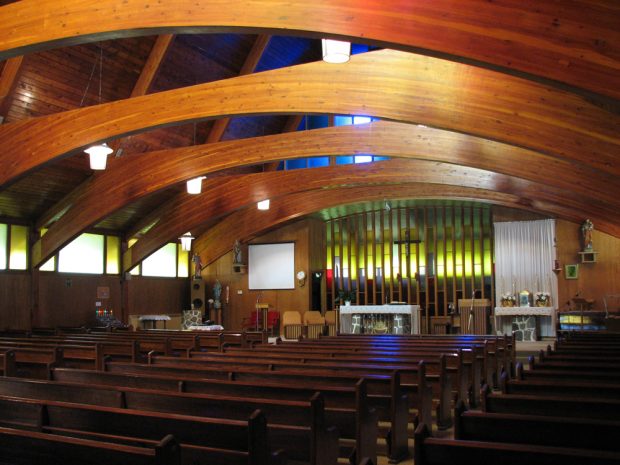 Color photograph, church interior with exposed curved wood beams and framework