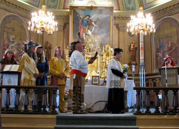 Color photograph, richly decorated church interior, religious celebration where the participants are dressed in period costumes.