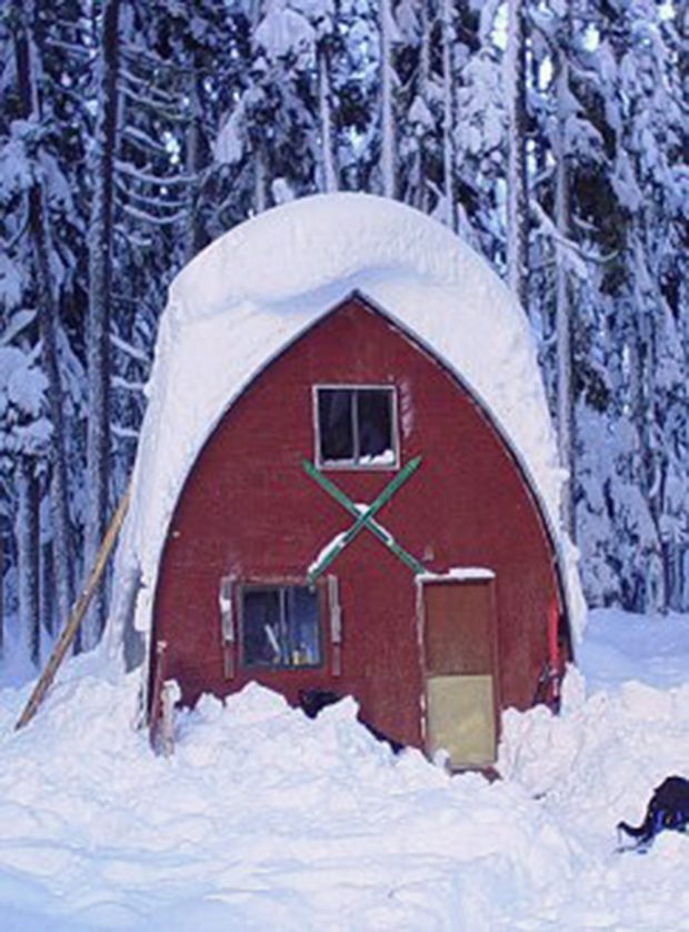The front end wall of the gothic arch hut in the winter before maintenance was performed and the hut was repainted.