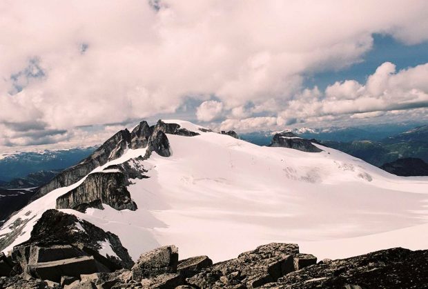 Two of the three peaks of the mountain are bare of but the third peak is obscured by snow. The BCMC mountaineers that first climbed the mountain in 1911 named it the Castle Towers because of its three distinct peaks.